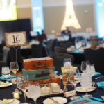 Suitcases, globes, and postcards decorated the tables while the Eiffel Tower and a Japanese temple illuminated the walls of Chandler Ballroom. Photo by Karen Pearlman.