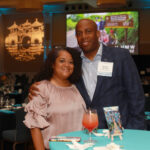 Lisa Patillo Miller ’96 and the Hon. Kerwin Miller Sr. '95 enjoy the cocktail hour at the 2024 Celebration of Giving, while a Center for International Education student slideshow plays in the background. Photo by Karen Pearlman.