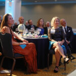 President Troy Paino and wife Kelly (right), who were the evening's hosts, and other guests listen to UMW student speakers talk about their international education experiences at Mary Washington. Photo by Karen Pearlman.