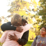 Patti Boise Kemp '69 and Kerwin Miller Sr. '95 share a hug at the Legacy Celebration. Photo by Karen Pearlman Photography.