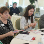From left: Alumni Board President Vicki Sprague Ravenel '77, member Katherine Redmiles '15, and President-Elect James Llewellyn '87, examine sensory toys handed out by Assistant Dean of Students Chris Porter before her presentation. These toys help calm students with autism spectrum disorder, Porter said. Photo by Karen Pearlman.