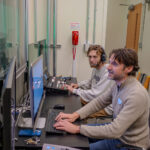 Mikhael Charnoff '95 and wife Katherine Valentine Charnoff '04 contributed a gift that helped pay for a production desk that increases accessibility. Cartland (foreground) and Steve test out the broadcast panel, which is housed in the production desk. Photo by Sam Cahill.