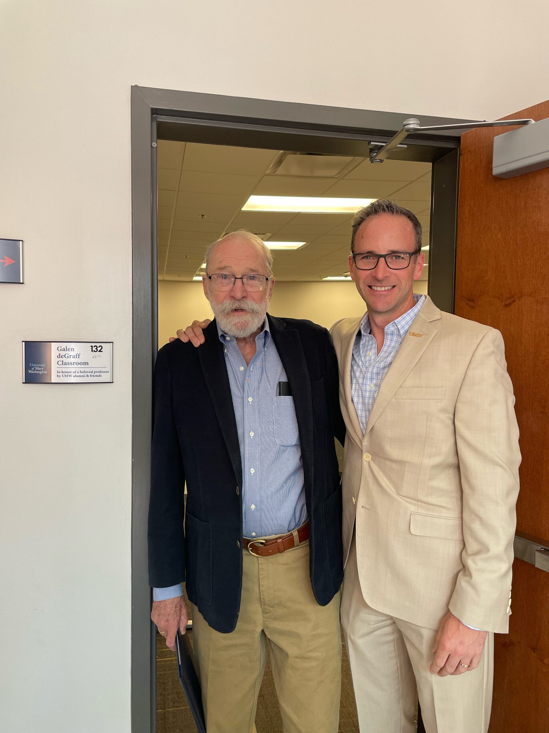 Professor Emeritus of Business Galen deGraff stands with Rob Strassheim '96 in the doorway of the Galen deGraff Classroom in Woodard Hall. Photo courtesy of Rob and Sarah Strassheim.