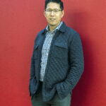 Jin Wong '97 poses for a picture in the College of Business. A business administration major at Mary Washington, he recently accepted the position of assistant general manager for baseball administration with the Chicago White Sox, after 24 years with the Kansas City Royals. Photo by Tom Rothenberg.
