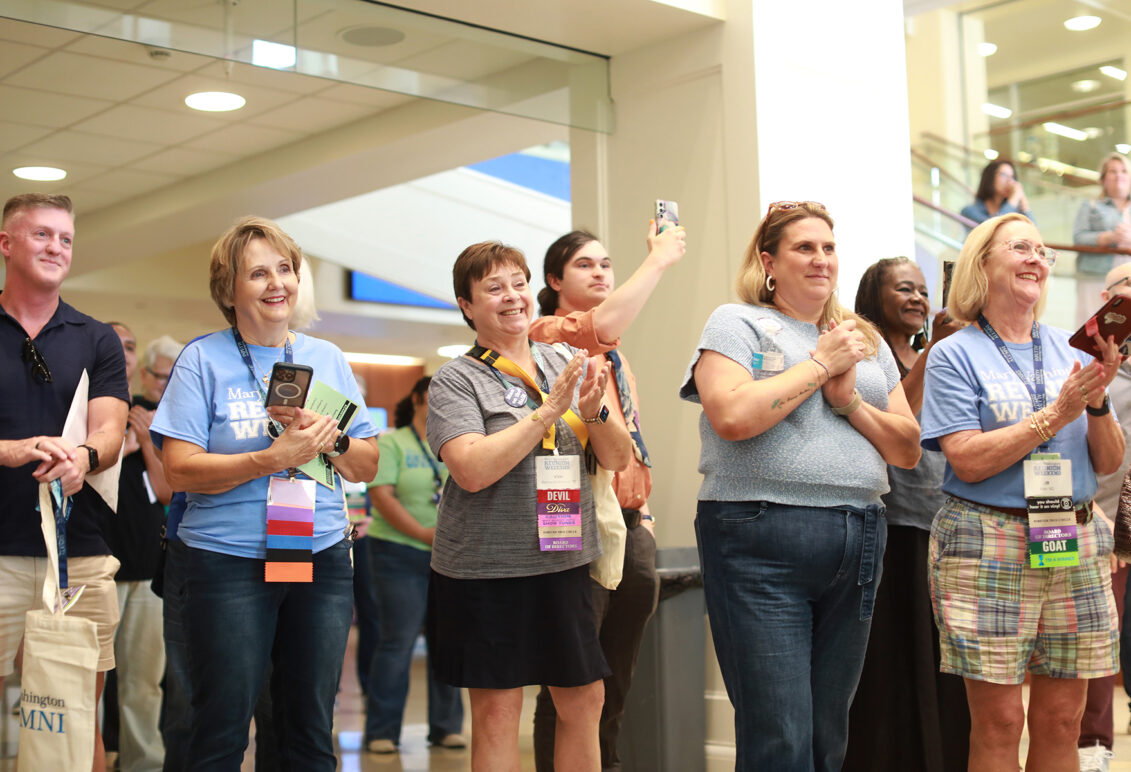 Members of the staff, including Director of First Year Admissions Sarah Lindberg ’08 (front), and the Alumni Association Board of Directors clap for Rucker following the unveiling of his portrait. Photo by Karen Pearlman.