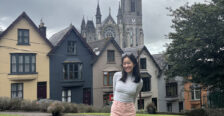 Mallory standing in front of colorful houses known as the "Deck of Cards," a popular tourist attraction in Cobh, Ireland.